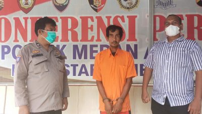 Pelaku diapit dua petugas Polsek Medan Area.